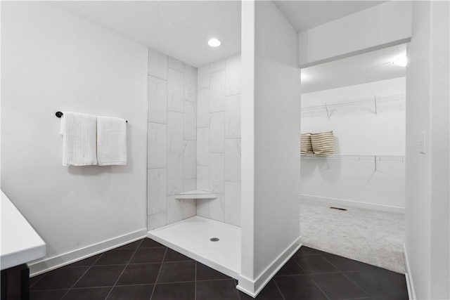 bathroom featuring tile patterned flooring, a textured ceiling, and walk in shower