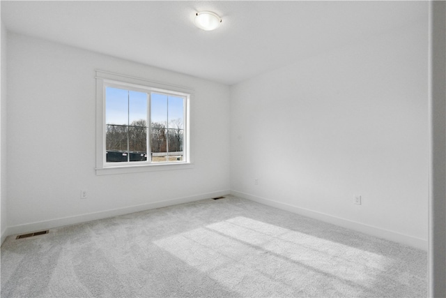 spare room featuring light colored carpet