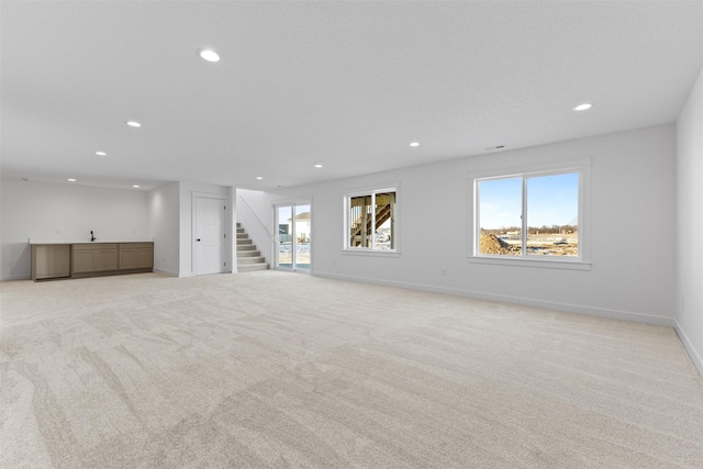 unfurnished living room featuring light colored carpet