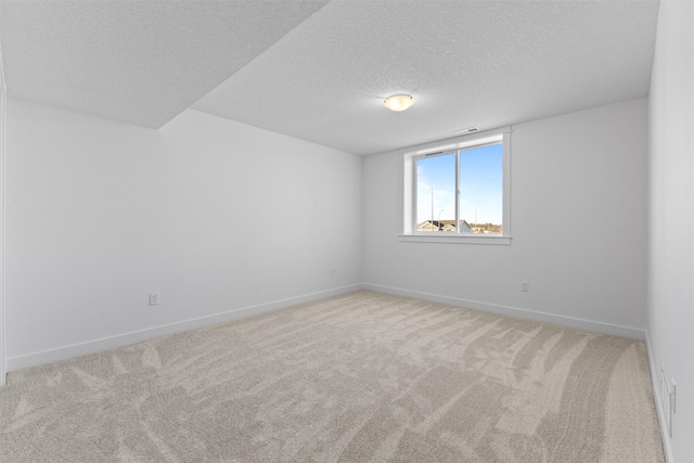 unfurnished room with light carpet and a textured ceiling