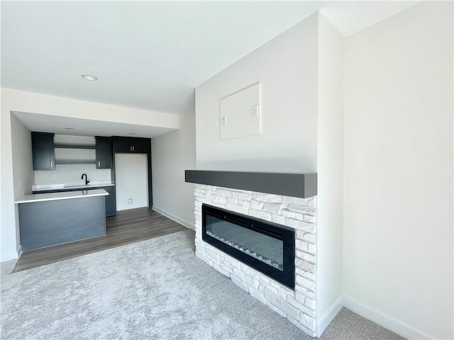 unfurnished living room with dark carpet and a fireplace