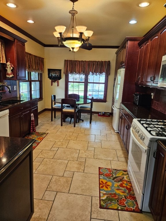 kitchen with white appliances, pendant lighting, sink, light tile floors, and a notable chandelier