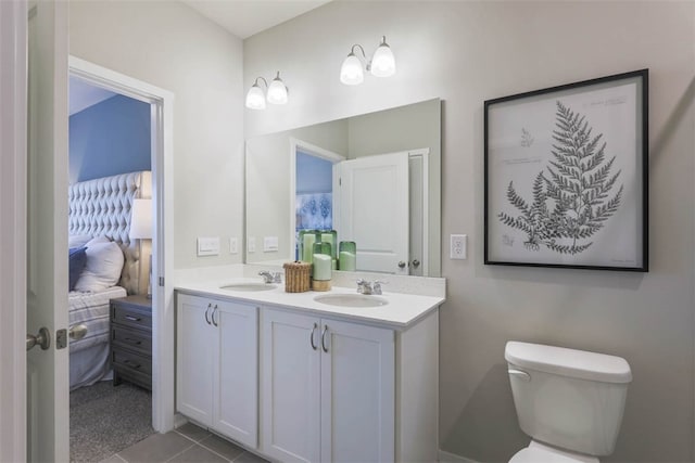 bathroom featuring dual bowl vanity, toilet, and tile flooring