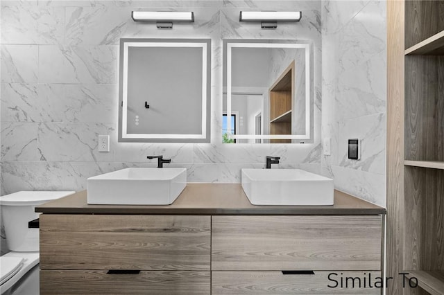 bathroom featuring vanity, decorative backsplash, and toilet