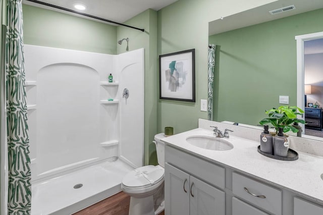 bathroom with hardwood / wood-style floors, a shower with curtain, large vanity, and toilet