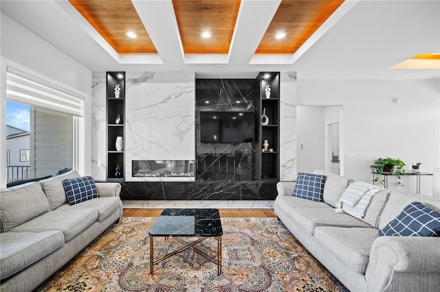 living room with wooden ceiling, a high end fireplace, hardwood / wood-style flooring, built in features, and beam ceiling