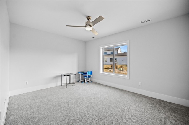 carpeted spare room featuring ceiling fan