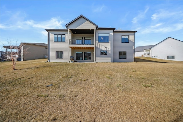 back of property featuring a balcony and a yard