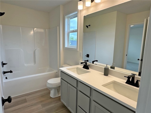 full bathroom featuring vanity,  shower combination, hardwood / wood-style flooring, and toilet