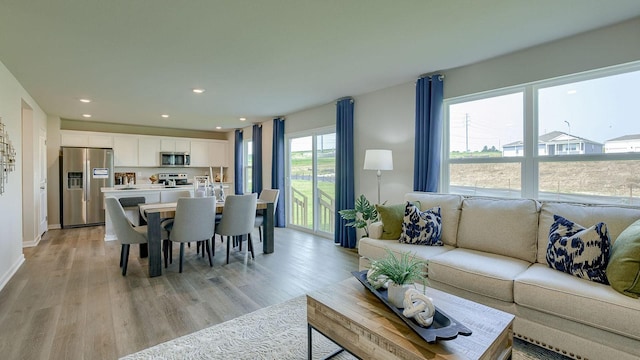 living area with light wood finished floors and recessed lighting