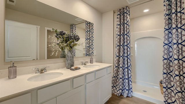 bathroom featuring hardwood / wood-style floors, walk in shower, and vanity