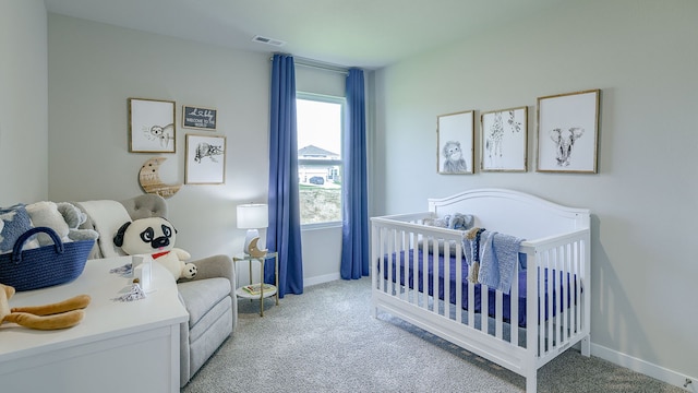 bedroom featuring light colored carpet and a crib