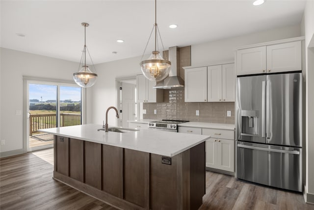 kitchen featuring white cabinets, stainless steel appliances, sink, and wall chimney range hood