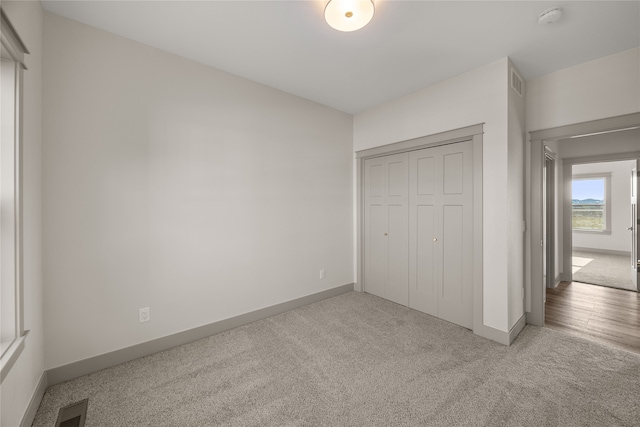 unfurnished bedroom with carpet flooring and a closet