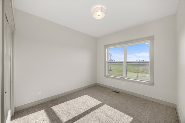 spare room featuring light colored carpet