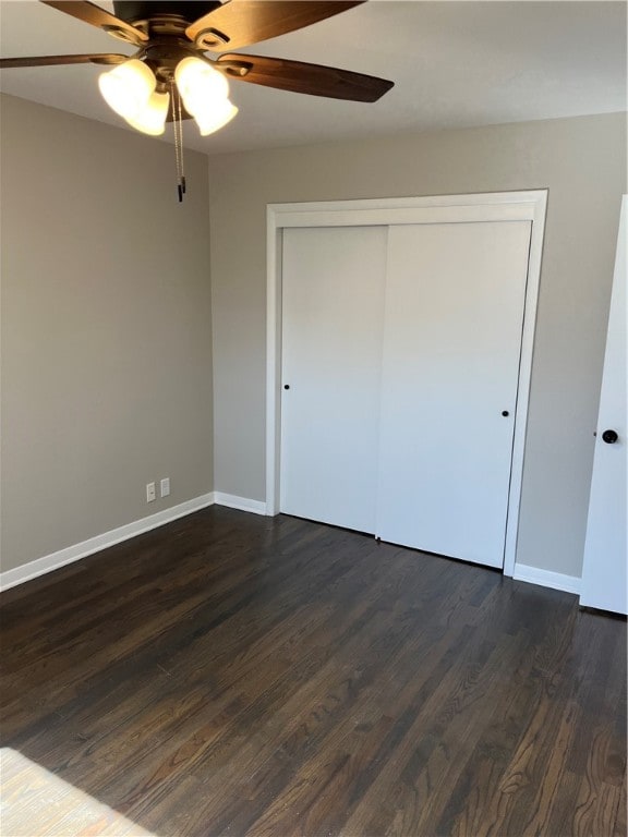 unfurnished bedroom featuring a closet, ceiling fan, and dark hardwood / wood-style flooring