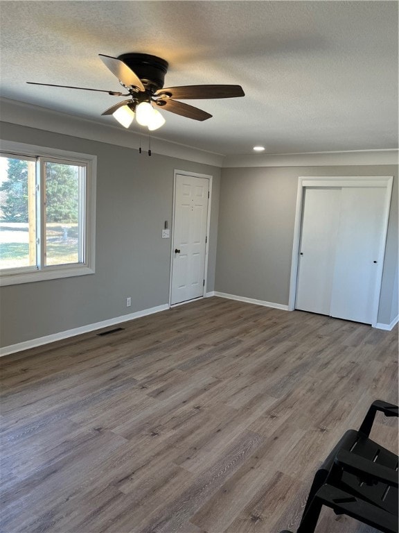 spare room with hardwood / wood-style floors, ceiling fan, and ornamental molding