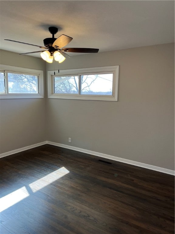 unfurnished room featuring dark hardwood / wood-style flooring, ceiling fan, and a wealth of natural light