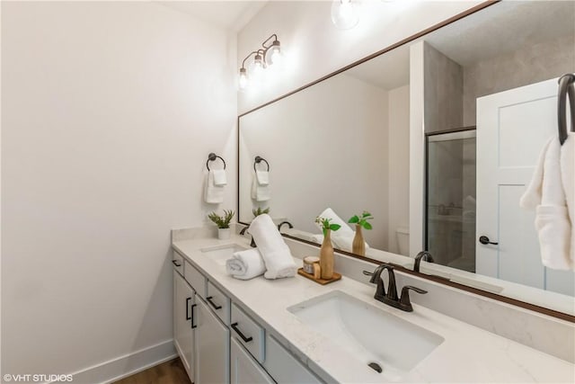 bathroom with toilet, vanity, a shower with shower door, and hardwood / wood-style flooring