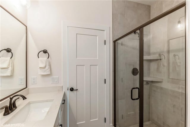 bathroom with vanity and a shower with door