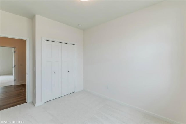 unfurnished bedroom featuring a closet and light wood-type flooring