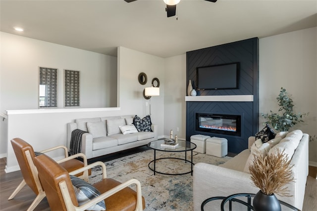 living room with ceiling fan, a fireplace, and hardwood / wood-style floors