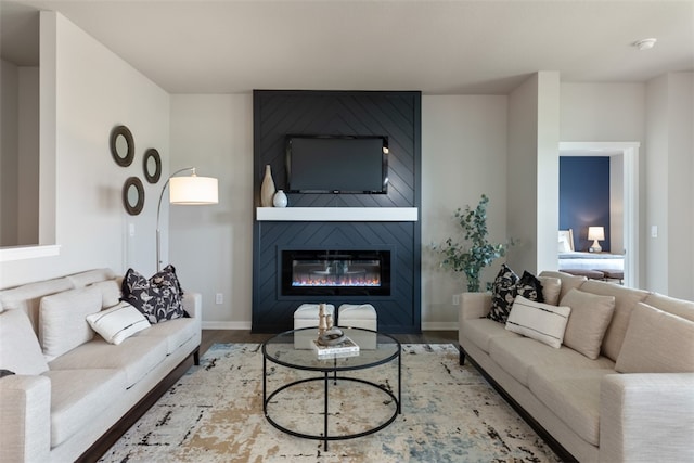 living room featuring hardwood / wood-style flooring and a large fireplace