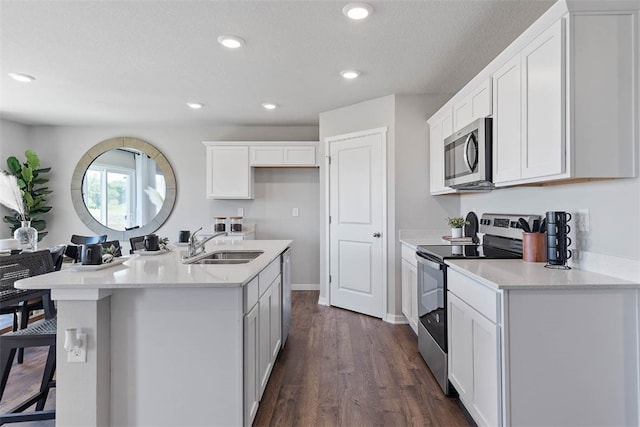 kitchen featuring white cabinetry, sink, stainless steel appliances, dark hardwood / wood-style flooring, and a kitchen island with sink