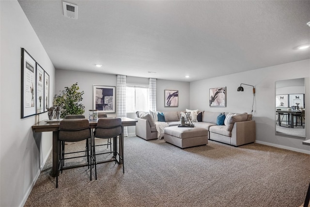 carpeted living room featuring a textured ceiling