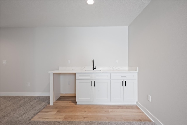 bar featuring white cabinetry and sink