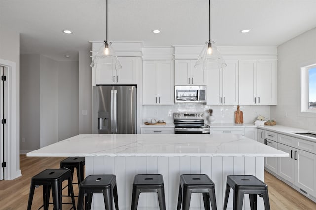 kitchen with white cabinets, a kitchen island, and appliances with stainless steel finishes