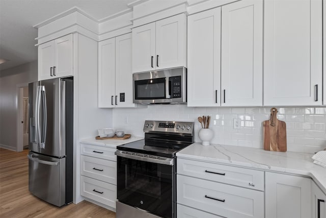 kitchen featuring white cabinets, stainless steel appliances, and light wood-type flooring