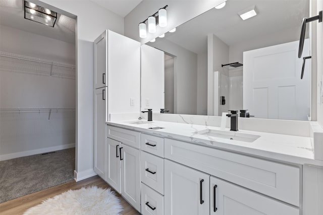 bathroom with a shower, hardwood / wood-style floors, and vanity