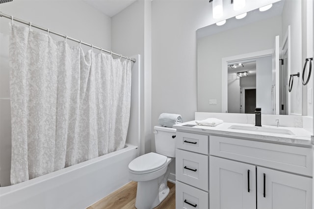 full bathroom with wood-type flooring, vanity, shower / tub combo, and toilet