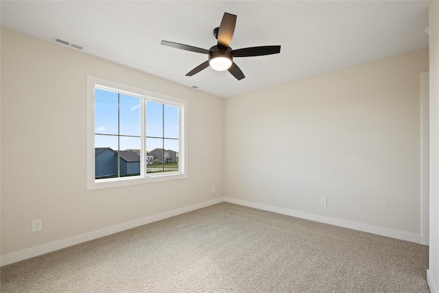 carpeted spare room featuring ceiling fan