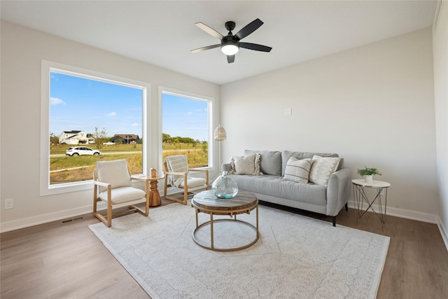 living room with wood-type flooring and ceiling fan