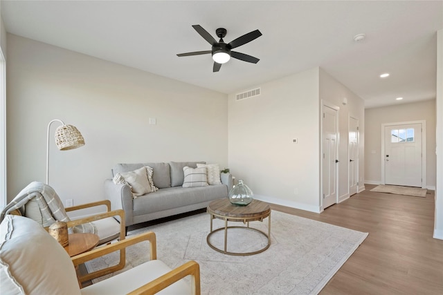 living room featuring ceiling fan and light hardwood / wood-style flooring