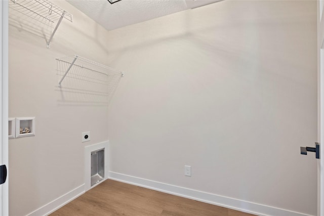 clothes washing area with washer hookup, hardwood / wood-style flooring, hookup for an electric dryer, and a textured ceiling