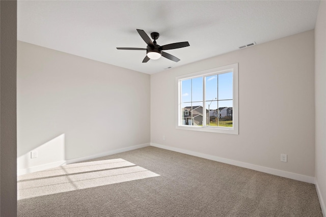 carpeted spare room featuring ceiling fan