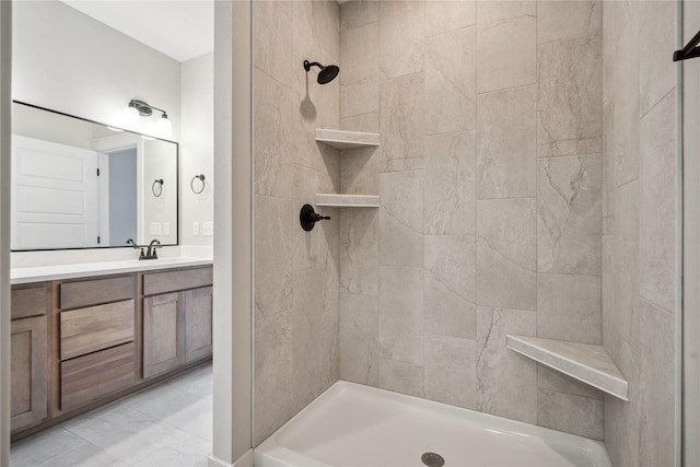 bathroom with vanity and a tile shower