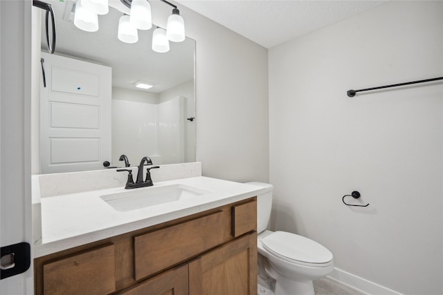 bathroom featuring vanity, a shower, and toilet