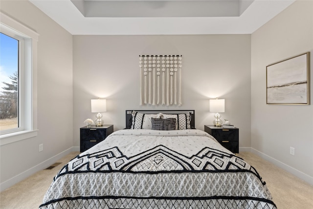 bedroom with multiple windows and light colored carpet