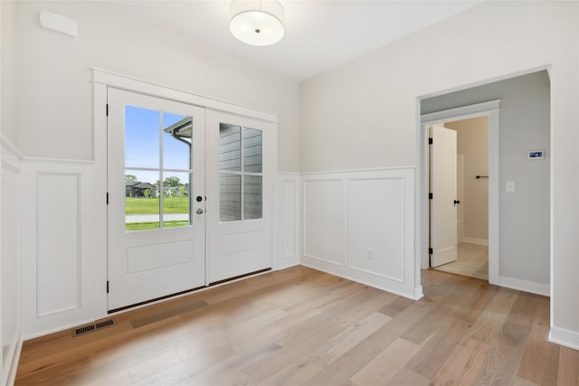 doorway with light wood-type flooring and french doors