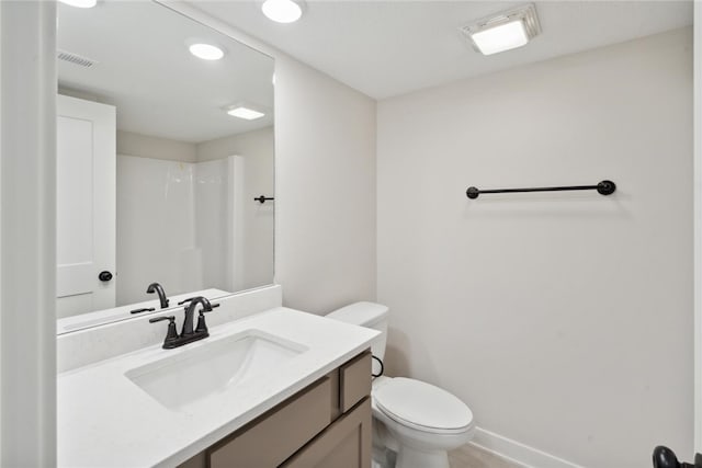 bathroom featuring walk in shower, vanity, and toilet