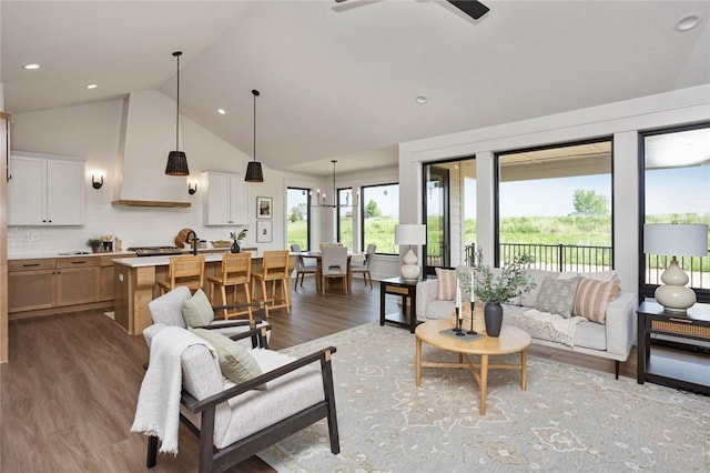 living room with a ceiling fan, high vaulted ceiling, wood finished floors, and recessed lighting