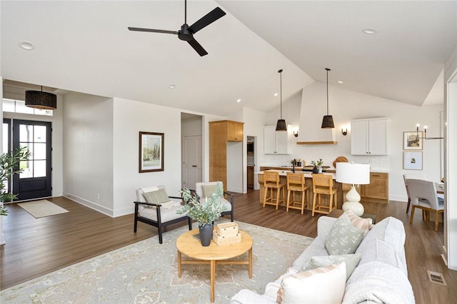 living room featuring visible vents, ceiling fan, wood finished floors, high vaulted ceiling, and baseboards