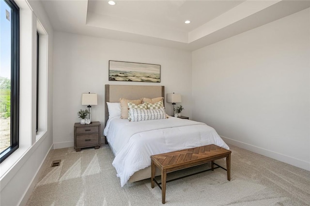 bedroom featuring light carpet, baseboards, a tray ceiling, and recessed lighting