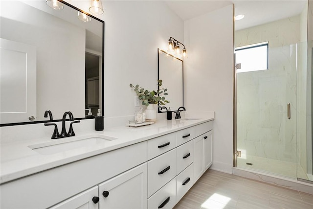 full bathroom with a sink, a marble finish shower, and double vanity