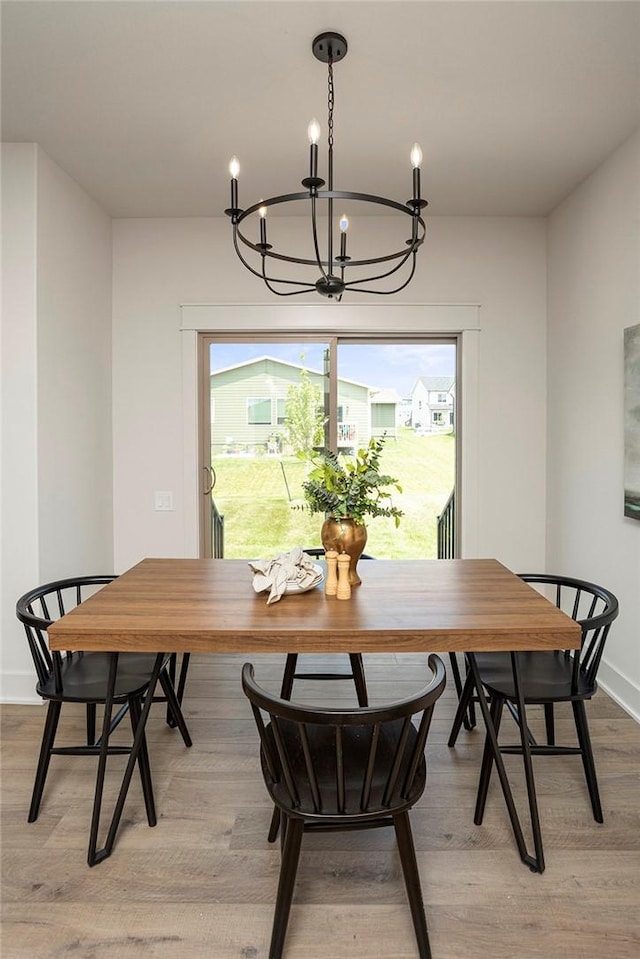 dining area featuring light wood-type flooring and an inviting chandelier