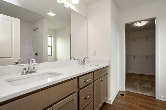 bathroom with hardwood / wood-style flooring and dual bowl vanity